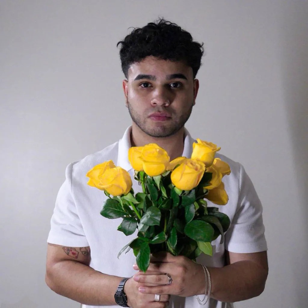En la foto se observa a ChemaC3tres sosteniendo un ramo de flores amarillas